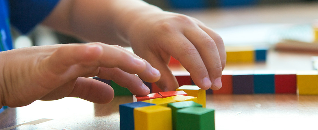 A student using blocks to solve a math problem.