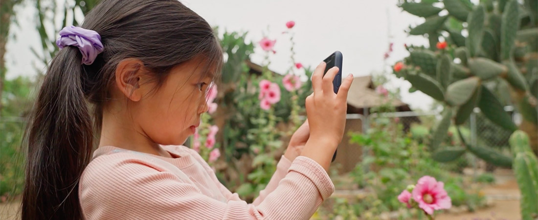 A photo of a child with a phone representing EDC Talks: Unlocking the Potential of WhatsApp in Learning