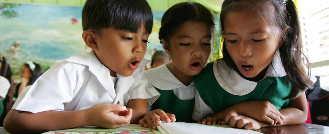 A photo of children reading representing To Improve Literacy, Examine the Book Supply Chain